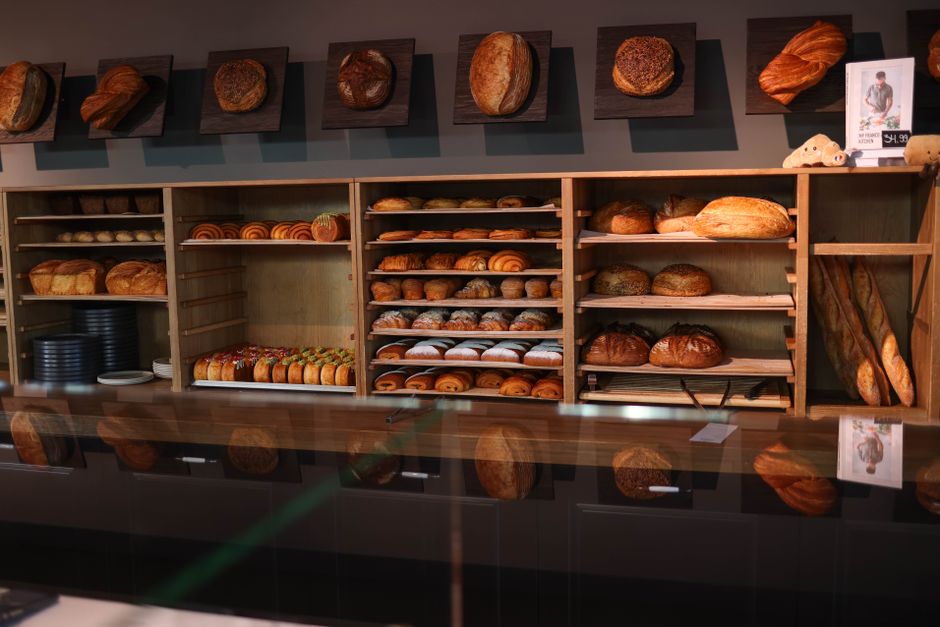 Fresh loaves of bread lined up on bakery shelves