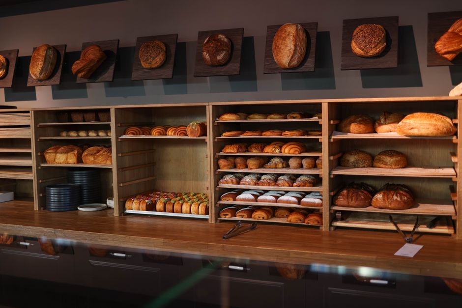 Fresh bread and pastries arranged on wooden bakery shelves
