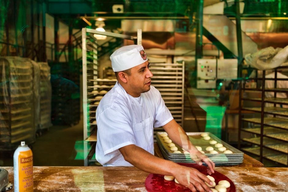 Baker shaping dough on a floured work table